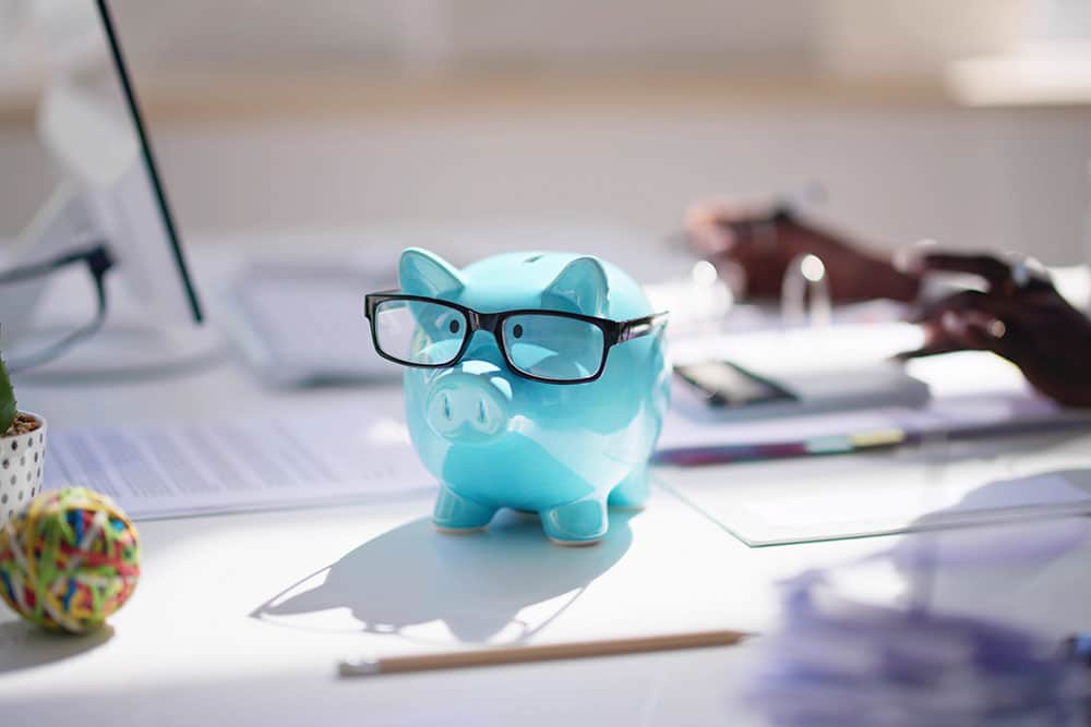 Piggy bank wearing glasses symbolizing smart savings strategies for veterinary care expenses